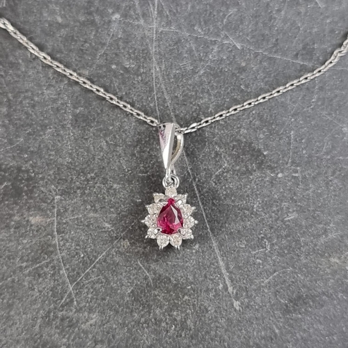 202 - A pendant set teardrop ruby and eleven diamonds, 10mm high, stamped Plat 900, on a chain stamped Pla... 