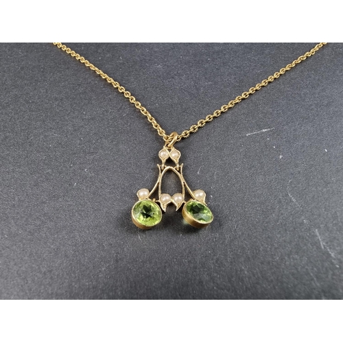 205A - An Edwardian yellow metal pendant, set two facetted peridots and six split pearls, 25mm high, on cha... 