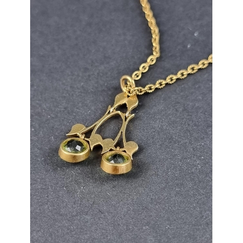 205A - An Edwardian yellow metal pendant, set two facetted peridots and six split pearls, 25mm high, on cha... 