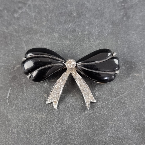 217 - An Art Deco white metal bow brooch, set central brilliant cut diamond and two black onyx with traili... 