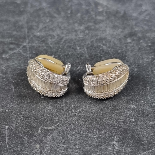 218 - A pair of white metal diamond ear studs, each set with a central band of fifteen baguette diamonds a... 