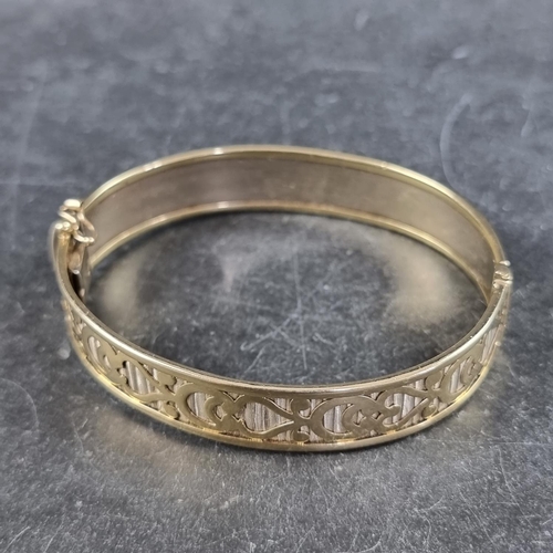 228 - A yellow metal hinged bangle, stamped 375, internal size 62 x 51mm.