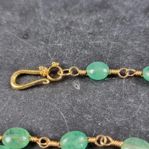 229 - An emerald bead and gilt metal necklace, having twenty three various sized beads, 38cm long.... 