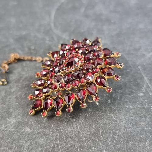 234 - A 19th century Bohemian gilt metal and garnet brooch/pendant, with locket back, 40mm high.... 