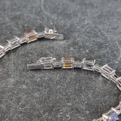 240 - A white metal multicoloured sapphire and diamond set bracelet, stamped 750, having twenty octagonal ... 