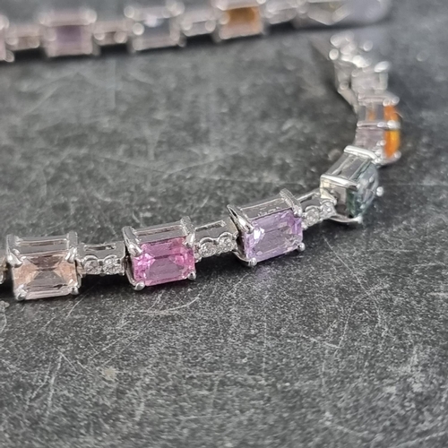 240 - A white metal multicoloured sapphire and diamond set bracelet, stamped 750, having twenty octagonal ... 