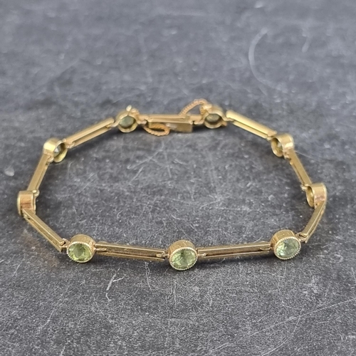 244 - A yellow metal link bracelet, set nine facetted peridots, marked 15, approximately 18cm long.... 