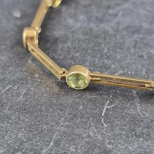 244 - A yellow metal link bracelet, set nine facetted peridots, marked 15, approximately 18cm long.... 