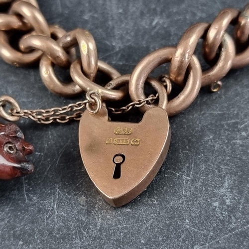 245 - A 9ct gold hollow gate link bracelet, with padlock clasp, 19g; with attached carved stone pig charm.... 