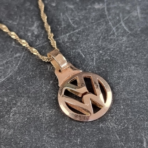 253 - A yellow metal VW pendant, 24mm high including bale, on a chain stamped 10k, 61cm long; together wit... 