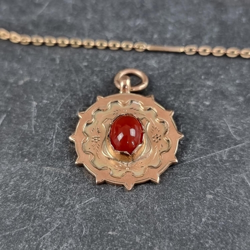 264 - A 9ct gold pendant, set central cabochon carnelian, 24mm diameter, gross weight 4.9g, on a rolled go... 