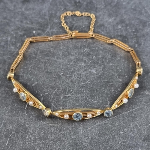 279 - An Edwardian yellow metal aquamarine and seed pearl bracelet, stamped '15c', 16cm long.... 