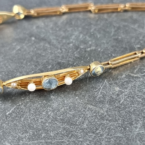 279 - An Edwardian yellow metal aquamarine and seed pearl bracelet, stamped '15c', 16cm long.... 