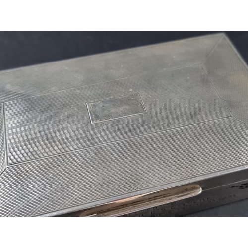 28 - An engine turned silver mounted cigarette box, having engraved presentation, by Harman Brothers, Bir... 