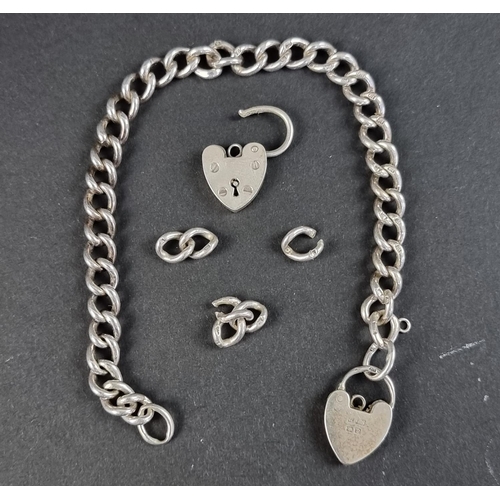 309 - A silver bracelet, having padlock clasp; together with another padlock clasp and several loose links... 