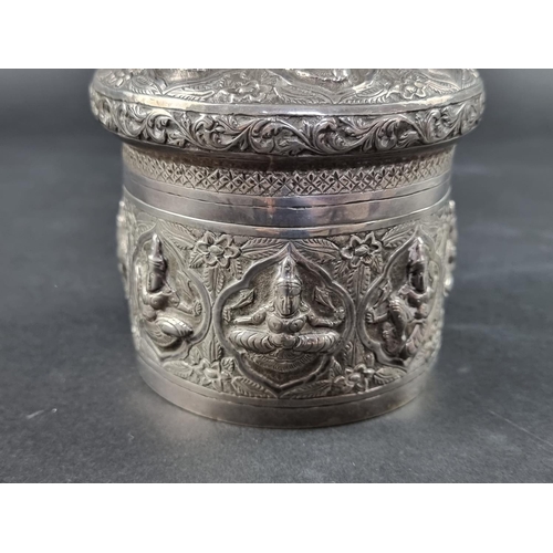 33 - An Eastern white metal cylindrical lidded box, probably Indian or Burmese, 9cm high, 11cm diameter.... 