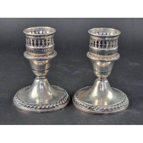 42 - A pair of American white metal candlesticks, stamped 'Sterling', 13cm high, weighted.... 