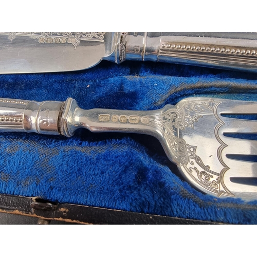 50 - A cased pair of Victorian silver fish servers, by Atkin Brothers, Sheffield 1879, handles filled.... 