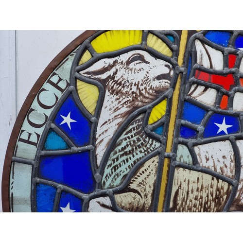 1379 - An old stained and leaded glass 'Lamb & Flag' circular panel, 54cm diameter.