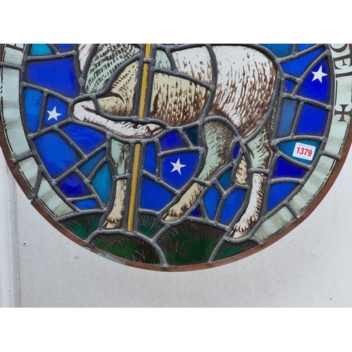 1379 - An old stained and leaded glass 'Lamb & Flag' circular panel, 54cm diameter.