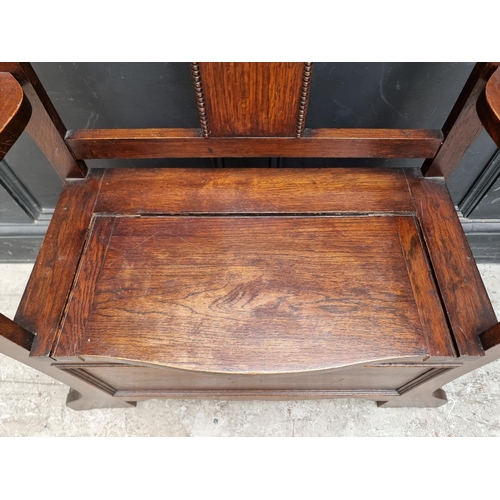 1004 - A small 1920s oak box seat settle/hall stand, 80.5cm wide.