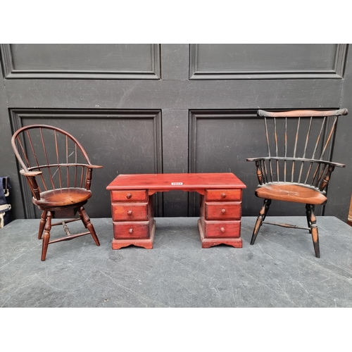 1017 - A miniature stained pine pedestal desk, 38cm wide; together with two miniature chairs, largest 38.5c... 