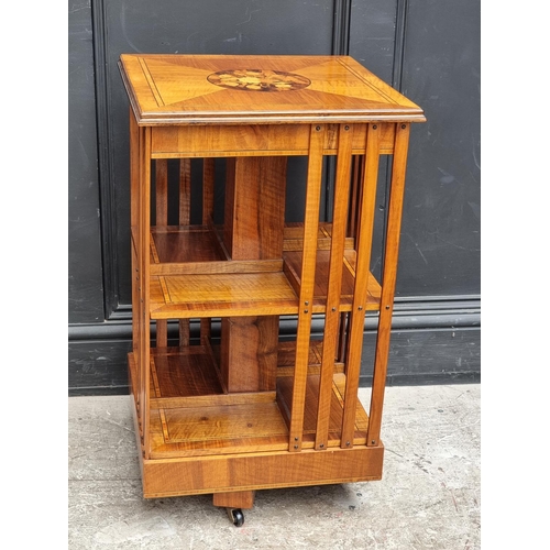 1032 - A small walnut, inlaid and tulip wood crossbanded revolving bookcase, 45cm wide.... 