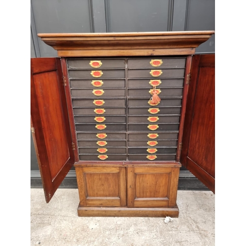 1035 - An unusual mahogany cabinet, the upper section fitted with twenty four small filing drawers, 142.5cm... 