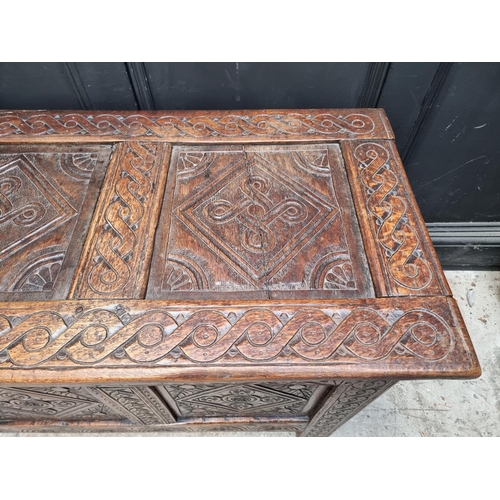 1048 - A late 17th century carved oak panelled coffer, 129cm wide, (some carving probably of a later d... 