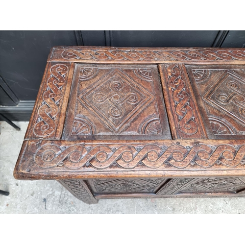 1048 - A late 17th century carved oak panelled coffer, 129cm wide, (some carving probably of a later d... 