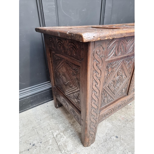 1048 - A late 17th century carved oak panelled coffer, 129cm wide, (some carving probably of a later d... 