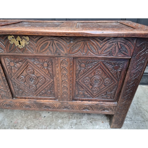 1048 - A late 17th century carved oak panelled coffer, 129cm wide, (some carving probably of a later d... 