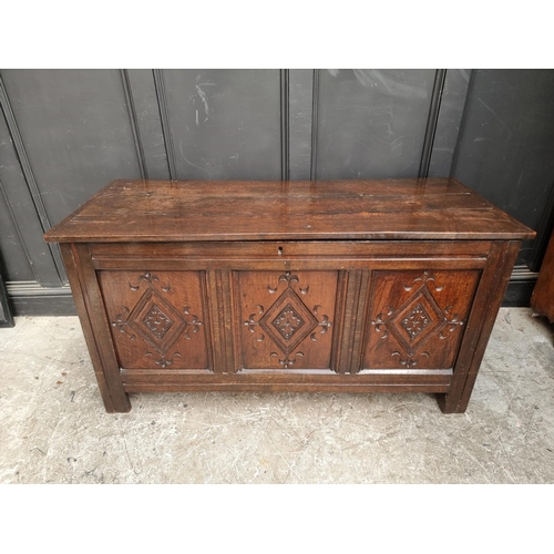 1049 - An antique carved oak panelled coffer, 136cm wide.