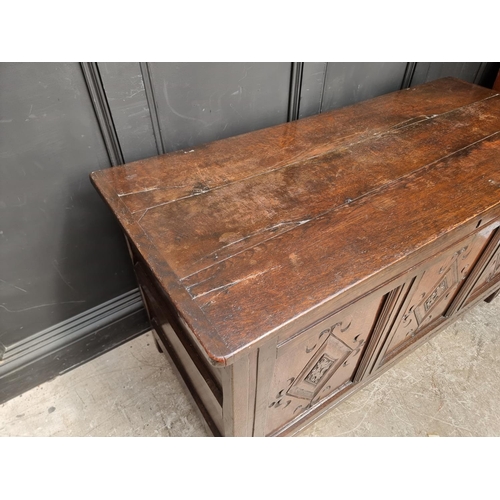 1049 - An antique carved oak panelled coffer, 136cm wide.