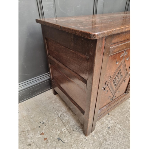 1049 - An antique carved oak panelled coffer, 136cm wide.