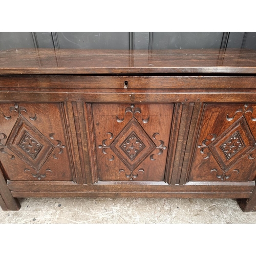 1049 - An antique carved oak panelled coffer, 136cm wide.