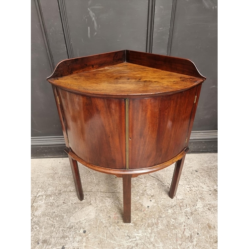 1051 - An antique mahogany bowfront corner washstand, 66.5cm wide.