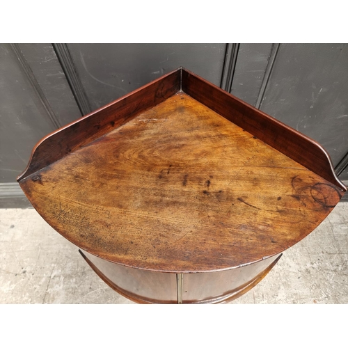 1051 - An antique mahogany bowfront corner washstand, 66.5cm wide.