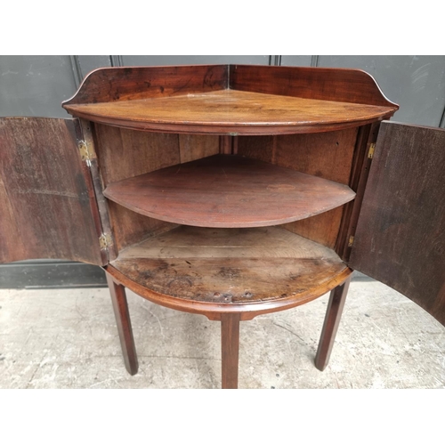 1051 - An antique mahogany bowfront corner washstand, 66.5cm wide.