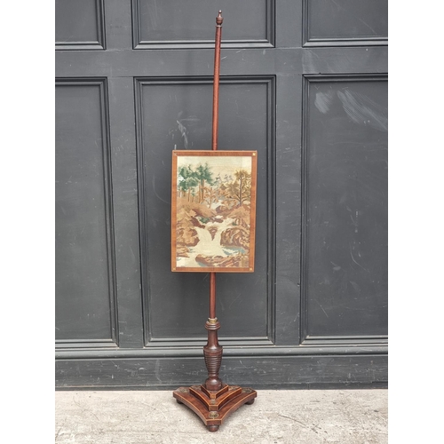 1052 - A George IV mahogany and brass pole screen, with later panel.