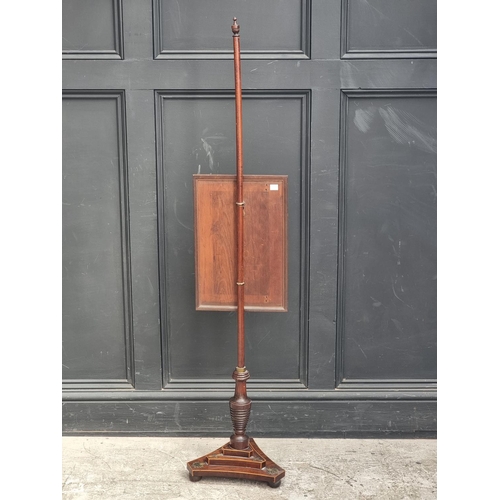 1052 - A George IV mahogany and brass pole screen, with later panel.