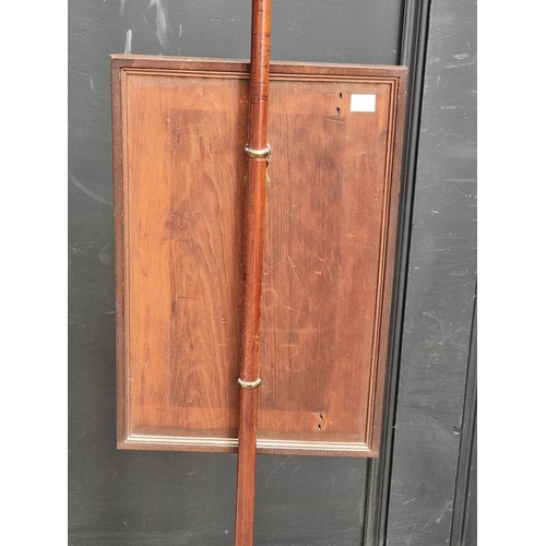 1052 - A George IV mahogany and brass pole screen, with later panel.