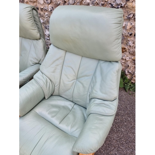 1068 - A pair of Himolla 'Chester' pale green leather reclining and swivel easy chairs.