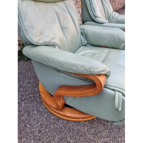 1068 - A pair of Himolla 'Chester' pale green leather reclining and swivel easy chairs.