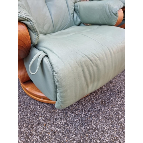 1068 - A pair of Himolla 'Chester' pale green leather reclining and swivel easy chairs.