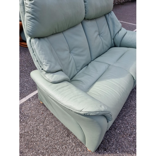 1068 - A pair of Himolla 'Chester' pale green leather reclining and swivel easy chairs.