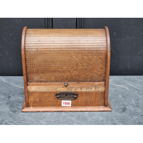 1086 - An early 20th century oak tambour top smoker's cabinet, 30cm wide.