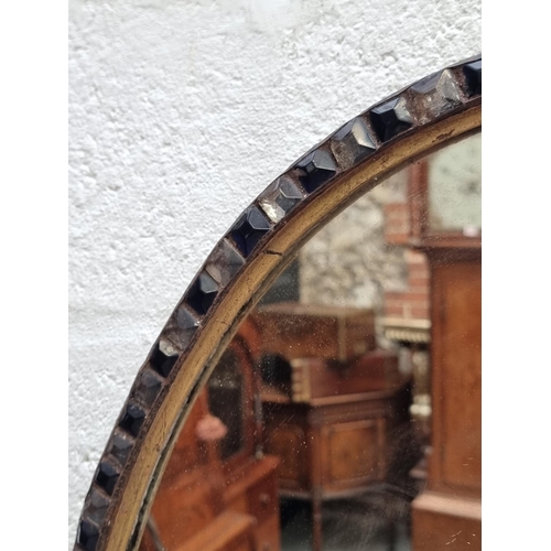 1089 - A large Irish style oval wall mirror, bearing label, 87 x 61.5cm.