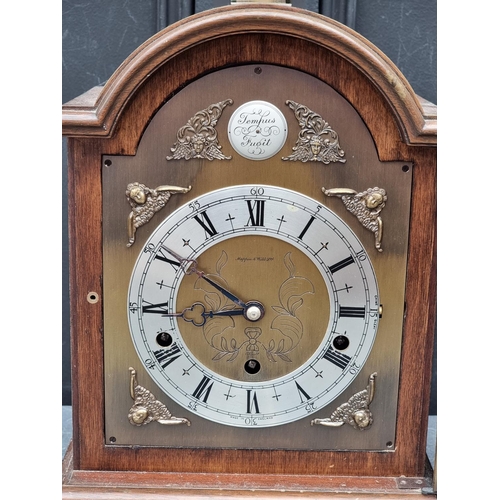 1097 - A walnut dome top mantel clock, by Elliott, striking on eight gongs, 37cm high.... 