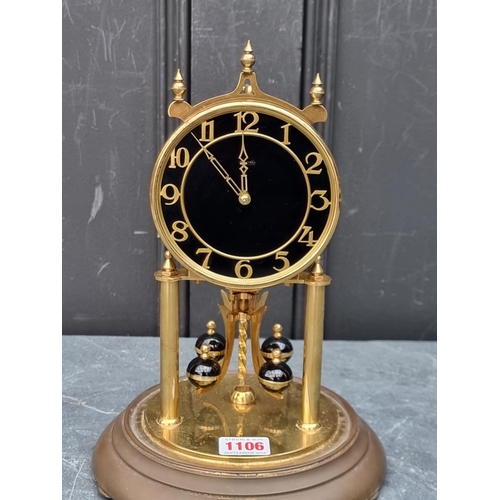 1106 - A brass anniversary clock, with glass dome, 29cm high.